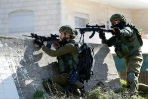 جنود الاحتلال يوجهان الرصاص اتجاه متظاهرين فلسطينيين في المخيم الامعري