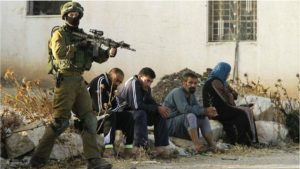 جندي من قوات الاحتلال يمنع الفلسطينيين من الدخول ( بي بي سي )